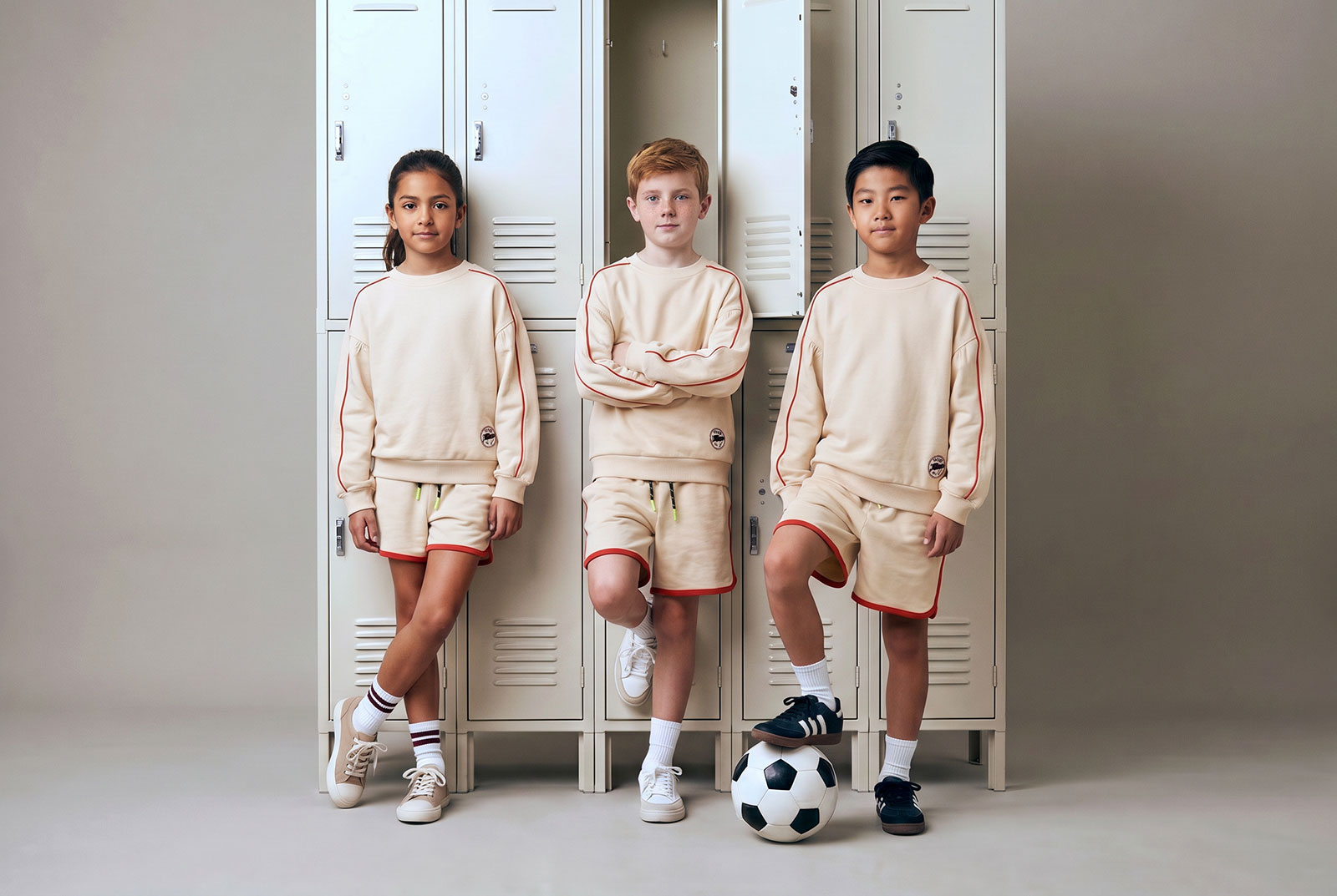Niños con equipaciones de fútbol infantiles ROOTS en tonos navy, crema y verde